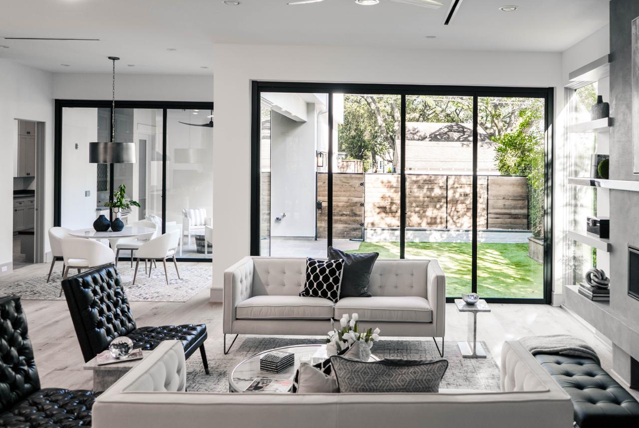 Modern living room with sliding glass wall conversion opening to outdoor space