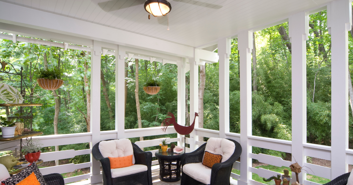 Modern front porch with wooden chairs and cushions, ideal starting point for enclosing a porch with style and comfort.