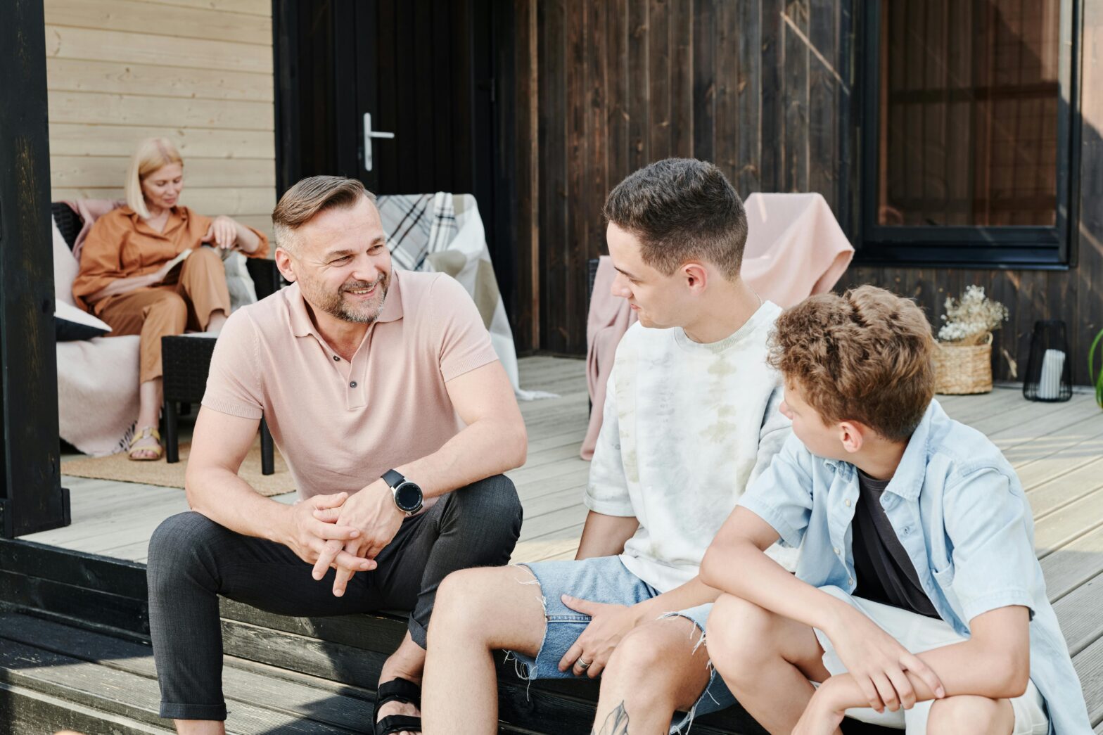 Family relaxing on a porch, relevant to sunroom additions vs patio conversions Texas.